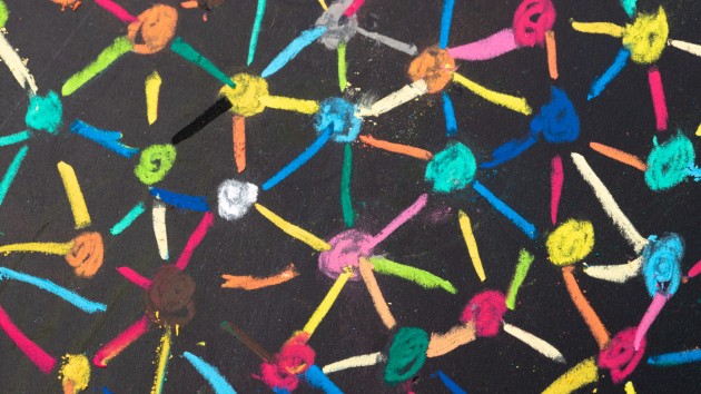 Different coloured dots connected with chalk on a blackboard